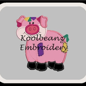 May include: A pink pig with a yellow, green, and purple patch on its back. The pig has a black nose and black eyes. The pig is standing on a gray background. The text "Koolbeanz Embroidery" is written below the pig.