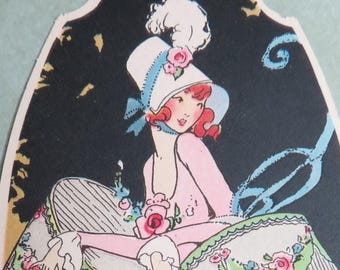 May include: Vintage illustration of a woman in a pink dress and hat, holding a large, decorated fan. The fan features floral designs. The artwork is set against a dark background with a decorative border. The text "PRINTED IN U.S.A." is visible.