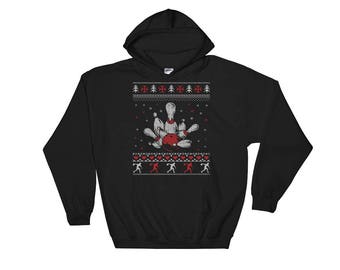 May include: Black hooded sweatshirt with a white and red Christmas-themed bowling pin design. The design features a bowling ball and pins with a red and white snowflake pattern. The text "Merry Bowling" is printed on the sweatshirt.
