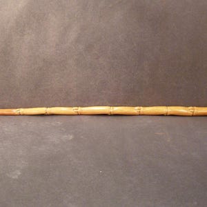 May include: A white ceramic mug with a black handle and the text "But First, Coffee" in a bold, black font. The mug is filled with a dark liquid, likely coffee, and sits on a light-colored surface.