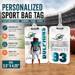 Puede incluir: Dos etiquetas rectangulares personalizadas para bolsas de deporte que miden 2,5 por 4,25 pulgadas. Una etiqueta muestra a un jugador de fútbol americano con uniforme turquesa con el texto Dolphins, Carson City Jr Pee Wee Football 2025 y Nikolas. La otra muestra el nombre Nikolas Christy y el número 93 con un logotipo de delfín.