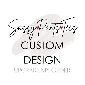 Pode incluir: Um fundo branco com uma pincelada cinza no centro. O texto "Sassy Pants Tees" está escrito em itálico preto com dois corações vermelhos. Abaixo do texto está "CUSTOM DESIGN" em letras pretas em negrito. O texto "UPGRADE MY ORDER" está escrito em azul claro abaixo do design.