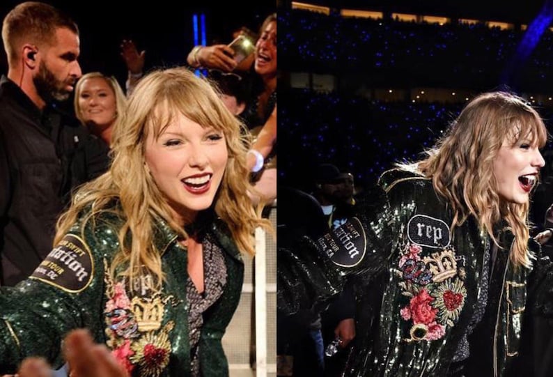 May include: A person wearing a dark green sequined jacket with embroidered floral and crown details. The jacket has patches that read "Reputation Stadium Tour" and "Rep". The person is smiling and appears to be at a concert.