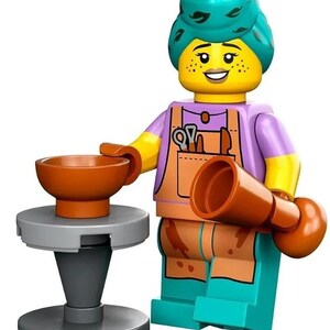May include: A Lego minifigure of a potter with a turquoise headscarf, purple shirt, orange overalls, and brown clay tools. The figure is holding a brown clay pot and standing next to a gray pottery wheel.