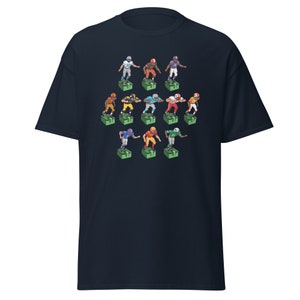 Short sleeve t-shirt with 11 retro style electric football game players printed across the front. Each player is roughly 2 inches by 3 inches and wearing different colorful uniforms. Dark blue shirt.