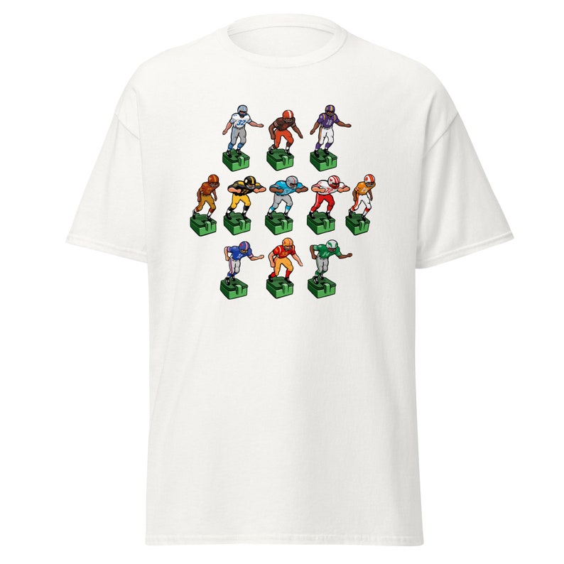 Short sleeve t-shirt with 11 retro style electric football game players printed across the front. Each player is roughly 2 inches by 3 inches and wearing different colorful uniforms. White shirt.