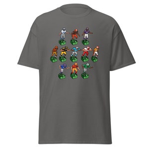 Short sleeve t-shirt with 11 retro style electric football game players printed across the front. Each player is roughly 2 inches by 3 inches and wearing different colorful uniforms. Gray shirt.