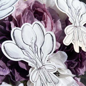 May include: A bouquet of five white crocuses tied with a ribbon, drawn in a watercolor style on a white background. The crocuses are arranged in a fan shape with the stems tied together at the base.