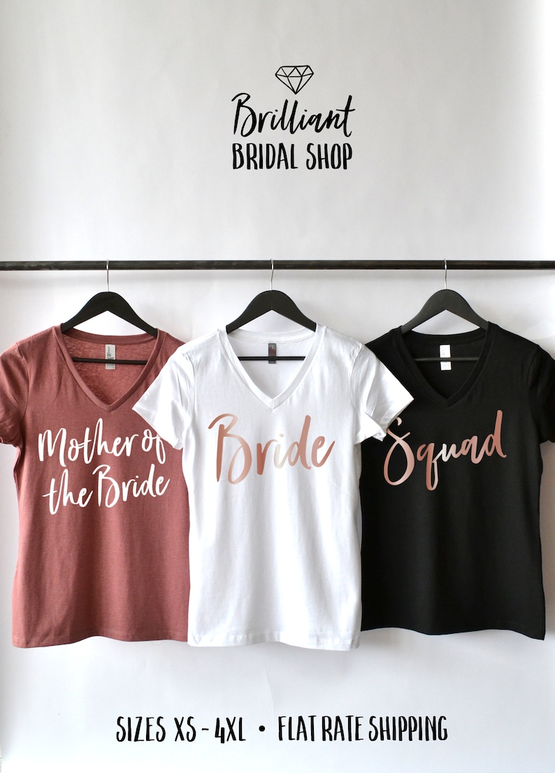 K&ouml;nnte beinhalten: Drei V-Ausschnitt-T-Shirts mit ros&eacute;goldenen Schriftz&uuml;gen auf verschiedenen farbigen Shirts. Die Shirts sagen "Mutter der Braut", "Braut" und "Squad".