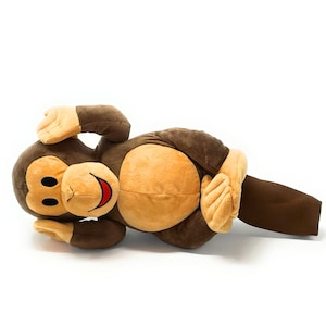 May include: A brown and tan plush monkey golf headcover. The monkey is lying on its back with its arms raised above its head. The headcover has a brown fabric body and a tan fabric face with black eyes and a red mouth.