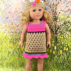 May include: A crocheted turkey costume for a doll, featuring a brown dress with pink, blue, and yellow accents, a matching hat with a turkey face, and brown shoes with pink trim.