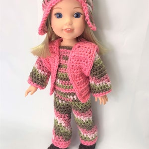 May include: A doll wearing a pink, green, and brown striped crocheted outfit with a matching hat. The doll has blonde hair and blue eyes.