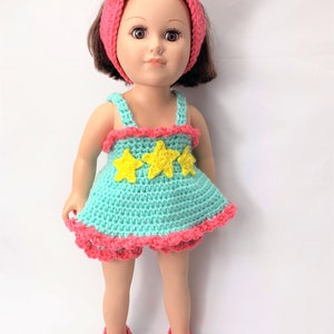 May include: A crocheted doll outfit in turquoise blue with yellow stars and pink trim. The outfit includes a dress, bloomers, headband, and shoes.