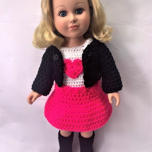 May include: A doll wearing a black crocheted jacket, a white crocheted shirt with a pink heart, a pink crocheted skirt, and black boots.