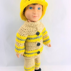 May include: A crocheted firefighter costume for a doll, featuring a yellow hat with the letters "FD" on the front, a tan jacket with yellow and gray stripes, and tan pants with yellow and gray stripes.