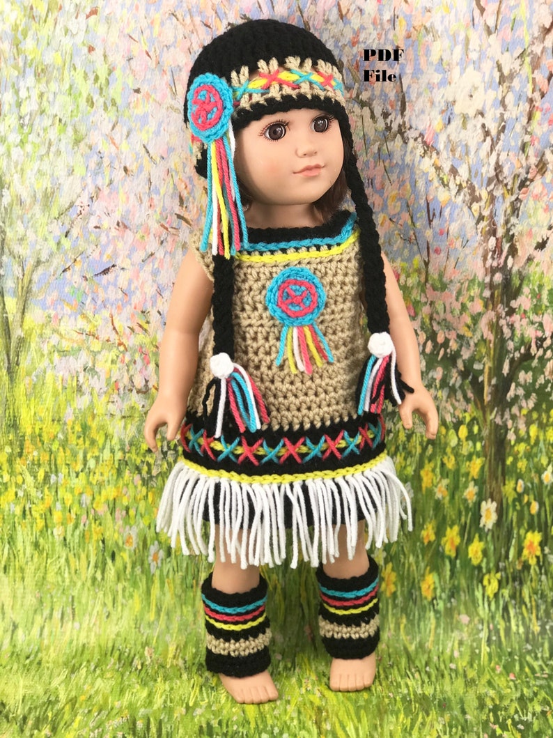 May include: A crochet doll outfit in Native American style, featuring a dress, leggings, and a hat with fringe. The outfit is in shades of brown, black, white, red, yellow, and blue.