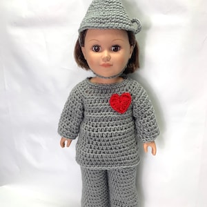 Puede incluir: Un disfraz de muñeca de crochet gris del Hombre de Hojalata del Mago de Oz. El disfraz incluye un sombrero, una camisa y pantalones. La camisa tiene un corazón rojo en la parte delantera.