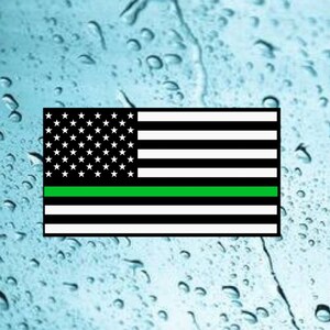 Puede incluir: Una bandera estadounidense con una fina l&iacute;nea verde a&ntilde;adida, que representa el apoyo a las fuerzas del orden.