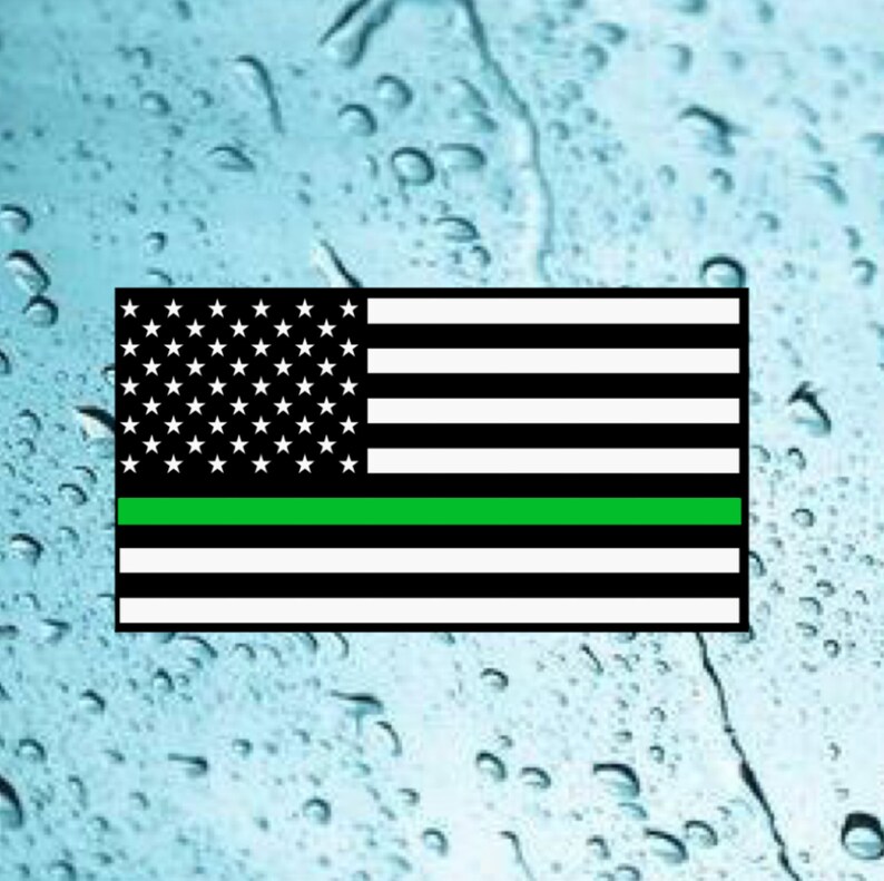 Puede incluir: Una bandera estadounidense con una fina l&iacute;nea verde a&ntilde;adida, que representa el apoyo a las fuerzas del orden.