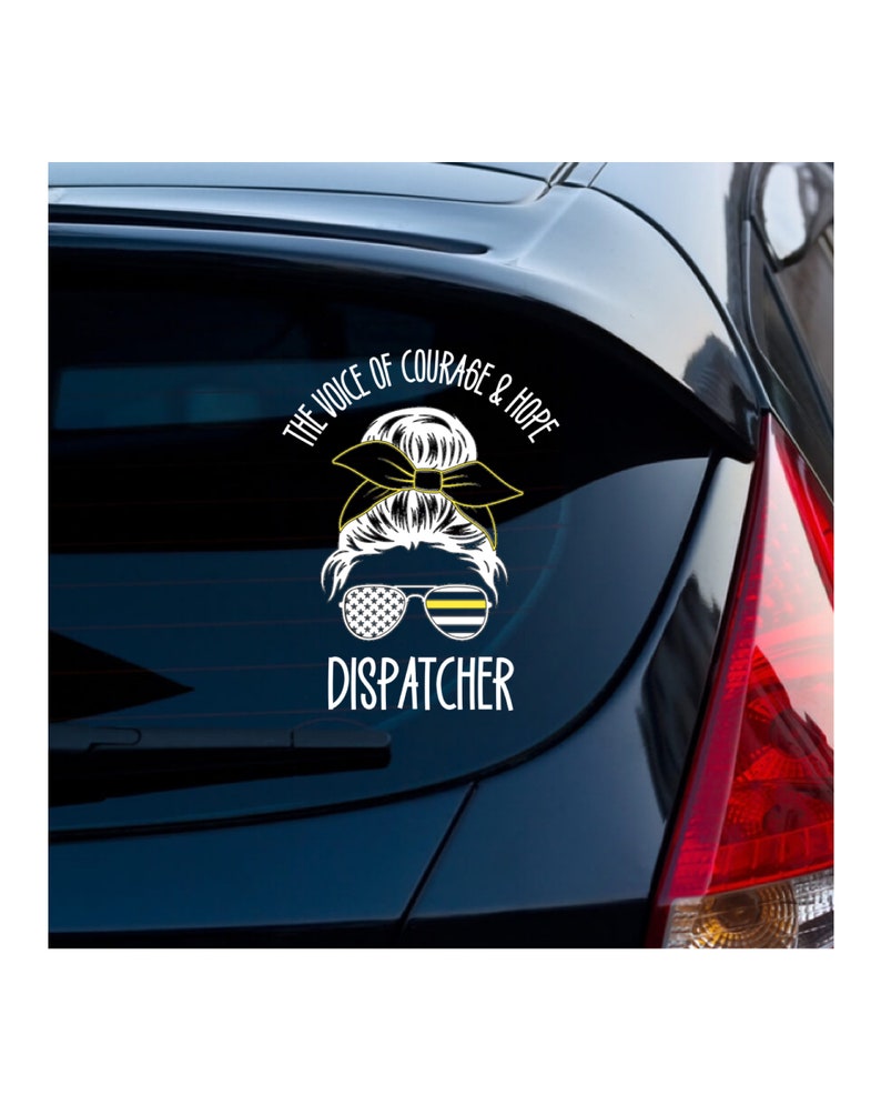 Puede incluir: Una pegatina de vinilo blanco con un dise&ntilde;o de bandera de l&iacute;nea fina negra y amarilla. La pegatina presenta a una mujer de dibujos animados con un mo&ntilde;o y gafas de sol. El texto "The Voice of Courage & Hope" y "Dispatcher" est&aacute;n en la pegatina.