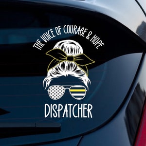 Puede incluir: Calcoman&iacute;a de vinilo blanco con una imagen estilizada de una mujer con un mo&ntilde;o, usando gafas de sol con un patr&oacute;n de bandera estadounidense y una l&iacute;nea azul delgada. El texto "THE VOICE OF COURAGE & HOPE" est&aacute; por encima de la imagen y "DISPATCHER" est&aacute; por debajo de la imagen.