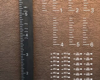May include: A black wooden growth chart with white markings and the text "LOVED BEYOND MEASURE". The chart measures up to 183 cm. Additional charts show age and grade levels. Digital download.