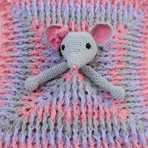 May include: A handmade crochet baby blanket in pink, gray, and lavender with a gray mouse head and arms attached. The blanket has a textured pattern and a pink border. The mouse has pink ears and black eyes.