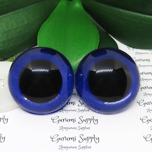 May include: Two blue plastic safety eyes with black pupils. The eyes are 1 inch in diameter.