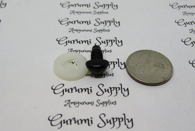 May include: Black plastic safety eyes for amigurumi projects, with a white plastic washer. The eyes are shown next to a US quarter for size comparison.