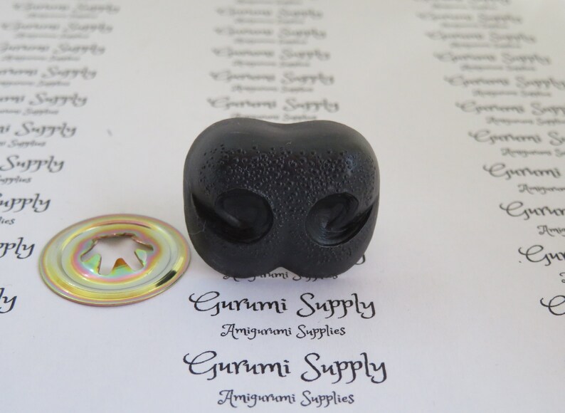 May include: Black plastic safety eyes for amigurumi projects. The eyes have a textured surface and are approximately 1 inch in diameter.