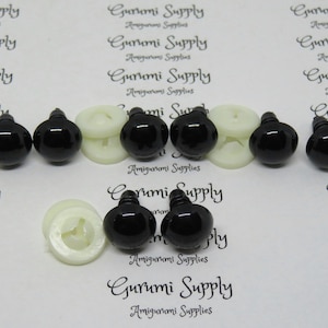 May include: A set of black plastic safety eyes with white plastic washers. The eyes are approximately 12 mm in diameter.