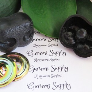 May include: Two black plastic safety eyes for amigurumi projects, with a textured surface. The eyes are 18mm in diameter and come with two iridescent metal washers.
