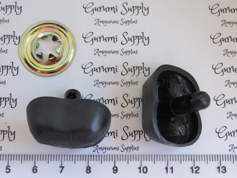 May include: Two black plastic buttons with a textured surface and a small black knob on top. A gold metal button with a star-shaped hole in the center is also included. The buttons are measured on a ruler in inches.