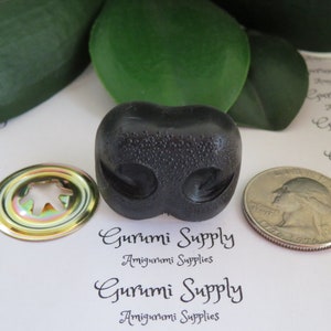 May include: Black plastic amigurumi safety eyes with a shiny gold metal washer. The eyes are about 1 inch in diameter.