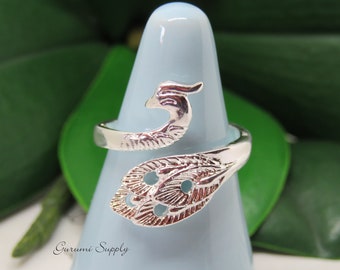 May include: Silver ring with a peacock design. The ring is open and adjustable. The peacock is facing to the right and has a detailed design.