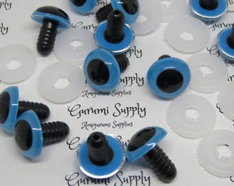 Puede incluir: Primer plano de un grupo de ojos de seguridad de plástico azul con pupilas negras y bordes plateados. Los ojos están unidos a postes de plástico negro. Los ojos son para usar en amigurumi y otras manualidades. Gurumi Supply Amigurumi Supplies está impreso en el fondo blanco.