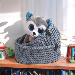 Peut inclure: Un panier de rangement en tricot gris avec deux sangles en cuir et un jouet en peluche husky gris &agrave; l'int&eacute;rieur.