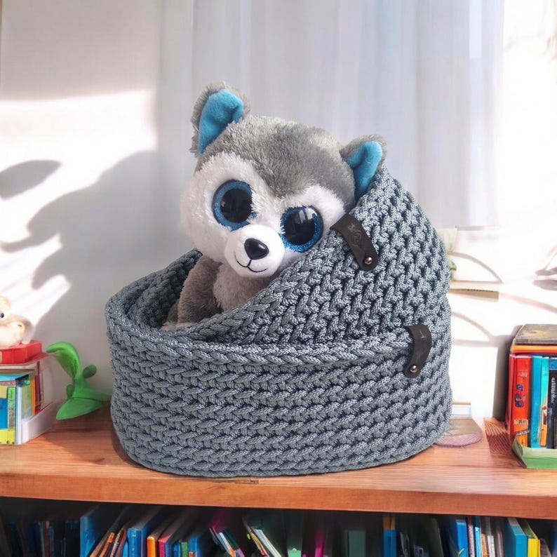 Peut inclure: Un panier de rangement en tricot gris avec deux sangles en cuir et un jouet en peluche husky gris &agrave; l'int&eacute;rieur.