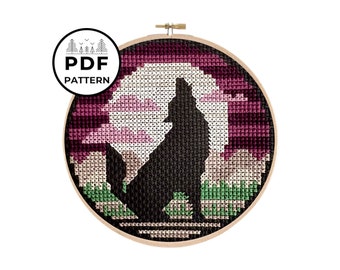 May include: A cross-stitch pattern of a wolf howling at the moon, with a pink and purple gradient background. The pattern is framed in a wooden hoop.