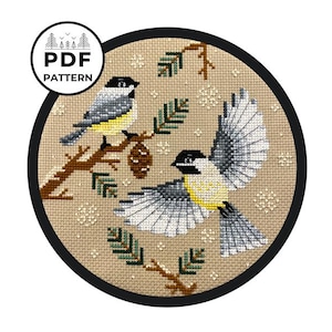 Könnte beinhalten: Kreuzstichmuster mit zwei Kohlmeisen auf einem Zweig mit Kiefernnadeln und Schneeflocken auf beigefarbenem Hintergrund. Das Muster trägt den Titel "PDF PATTERN".