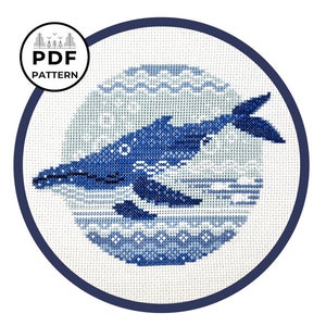 May include: A blue whale cross stitch pattern with a white background. The whale is swimming in a circle with a blue and white wave pattern.