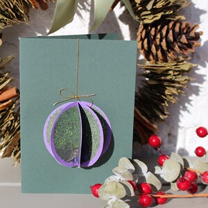Biglietto di Natale 3D. Pallina di carta fatta a mano a forma di pavone, viola e verde