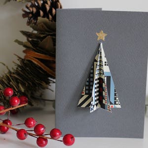 Tarjeta navideña 3D hecha a mano con diseño geométrico de estilo escandinavo, árboles de Navidad, edificios y arquitectura