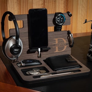 May include: A wooden desktop organizer with compartments for a phone, watch, wallet, and other accessories. The organizer has a personalized nameplate that reads "DAVID".