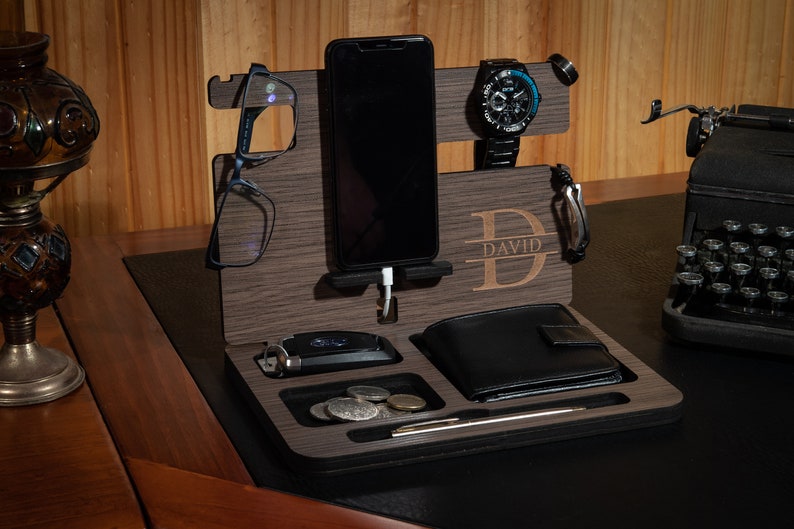 May include: A wooden desktop organizer with a phone stand, watch holder, glasses holder, wallet slot, and a key hook. The organizer is personalized with the name "DAVID".