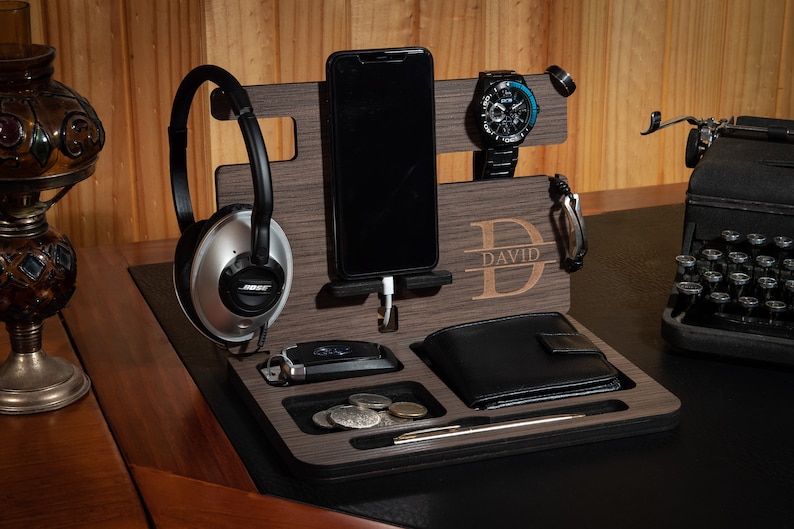May include: A wooden desktop organizer with compartments for a phone, watch, wallet, and other accessories. The organizer has a personalized nameplate that reads "DAVID".