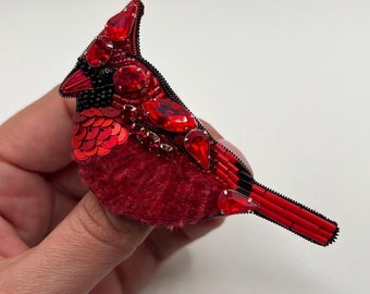 Broche met rode kardinaalkralen: vogelspeld chenille en rocaille