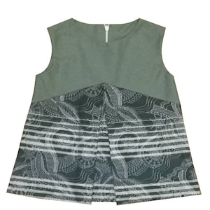 May include: A sleeveless top with a green bodice and a black and white patterned skirt. The skirt has a white stripe pattern and a black and white paisley design.