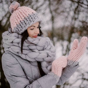 lady outdoors in winter wearing chunky knit mittens pom pom hat and scarf made of merino wool