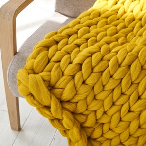 Mustard colour chunky merino blanket throw on an armchair